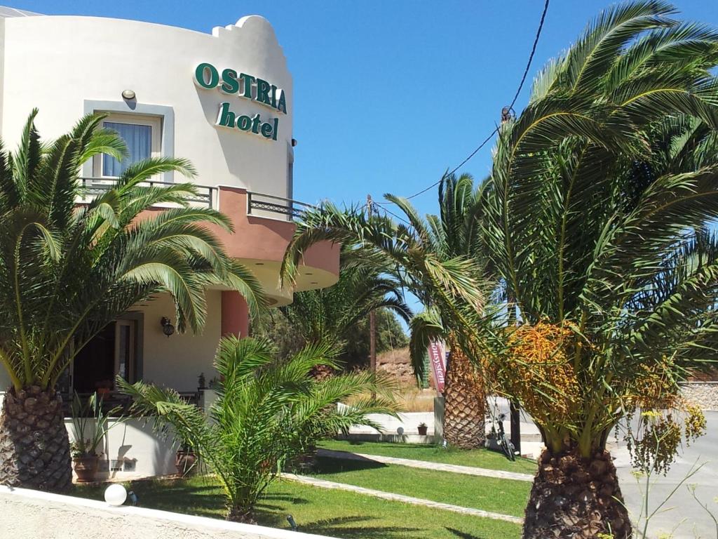 古卡斯特隆Ostria Hotel的前面有棕榈树的酒店