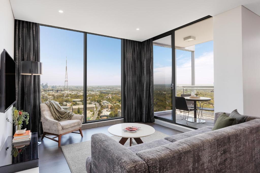 悉尼车士活美利通公寓式酒店的带沙发和落地窗的客厅