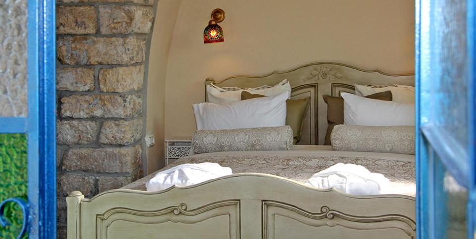 萨法德贝特哈奥曼尼旅馆的卧室配有带白色枕头的大床