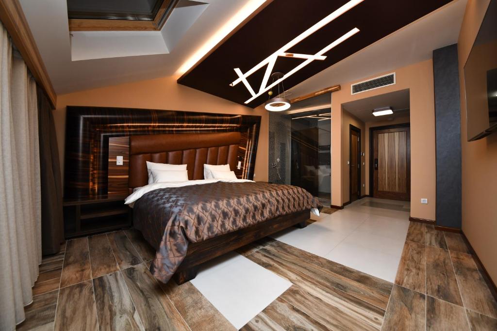 洛兹尼察Hotel Havana Loznica的带一张大床和一个壁炉的卧室