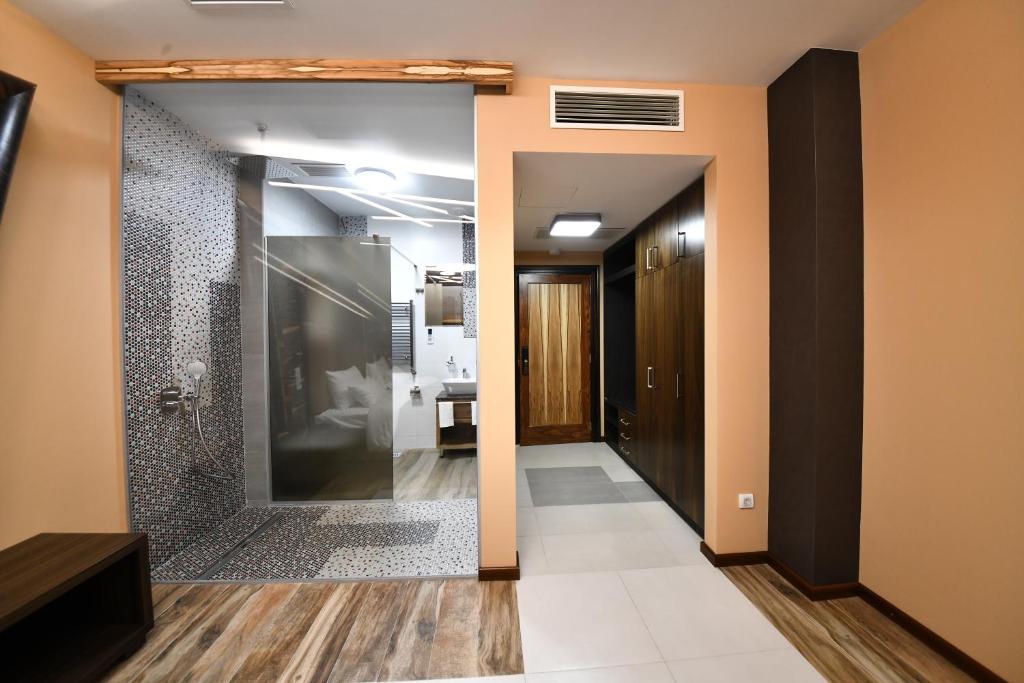 洛兹尼察Hotel Havana Loznica的走廊设有玻璃门,通往浴室