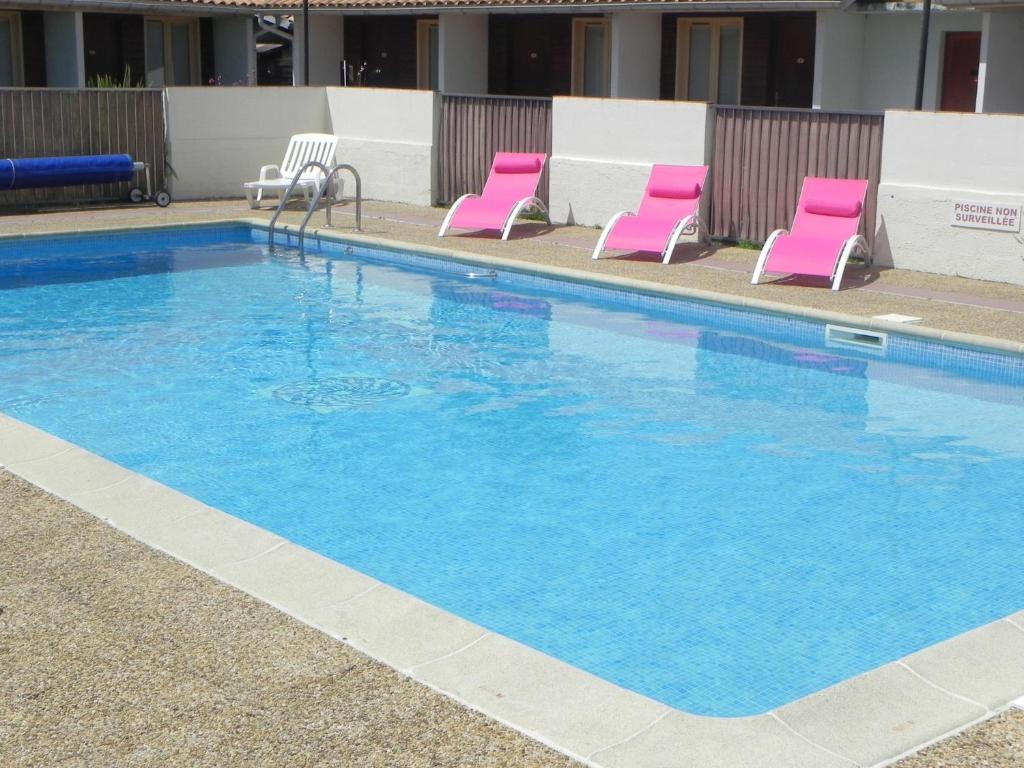 乌尔坦皮斯酒店的酒店设有一个大型游泳池,游泳池内摆放着粉红色的椅子