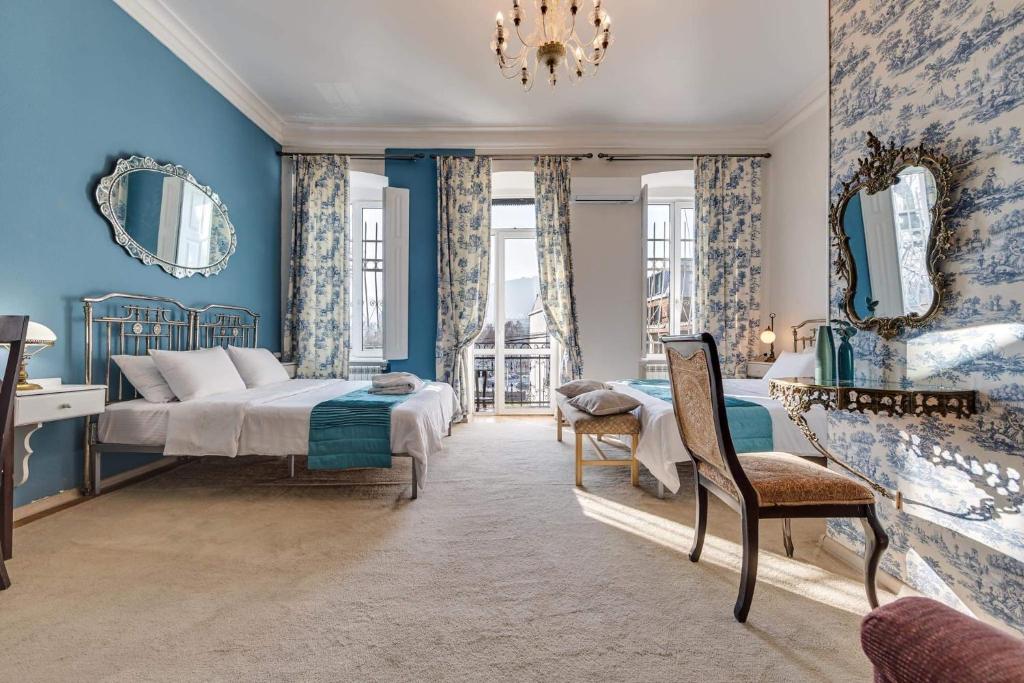 第比利斯House 52 Boutique Hotel的卧室拥有蓝色的墙壁,配有一张床和椅子