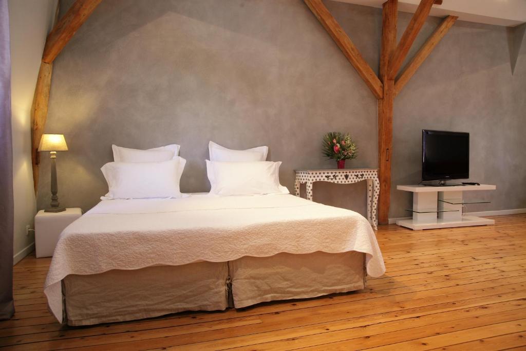 朗热里斯花朵公寓的一间卧室配有一张带白色床单的床和一台电视。