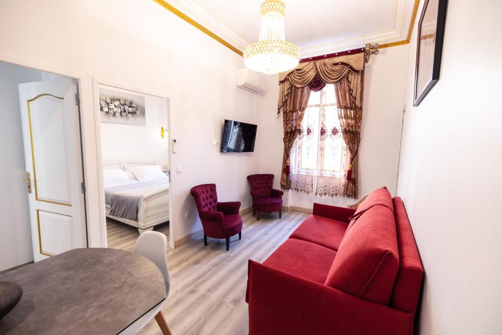 纳博讷Appartement Maison de L'Église du Couvent的客厅配有红色的沙发和床。