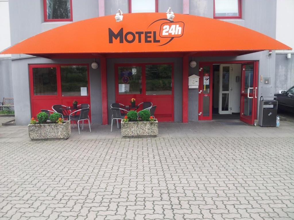 汉诺威汉诺威24小时汽车旅馆的拥有橙色屋顶和桌椅的汽车旅馆
