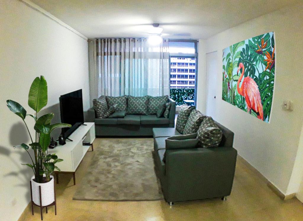 巴拿马城Habitaciones privadas en un departamento encantador的客厅配有两张沙发和一台电视机