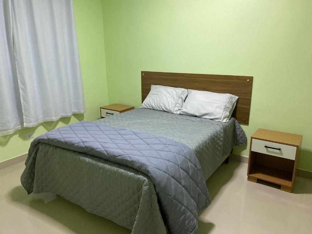戈亚斯州上帕莱索Suítes Acolhedoras da Diva的一间卧室配有床和2个床头柜