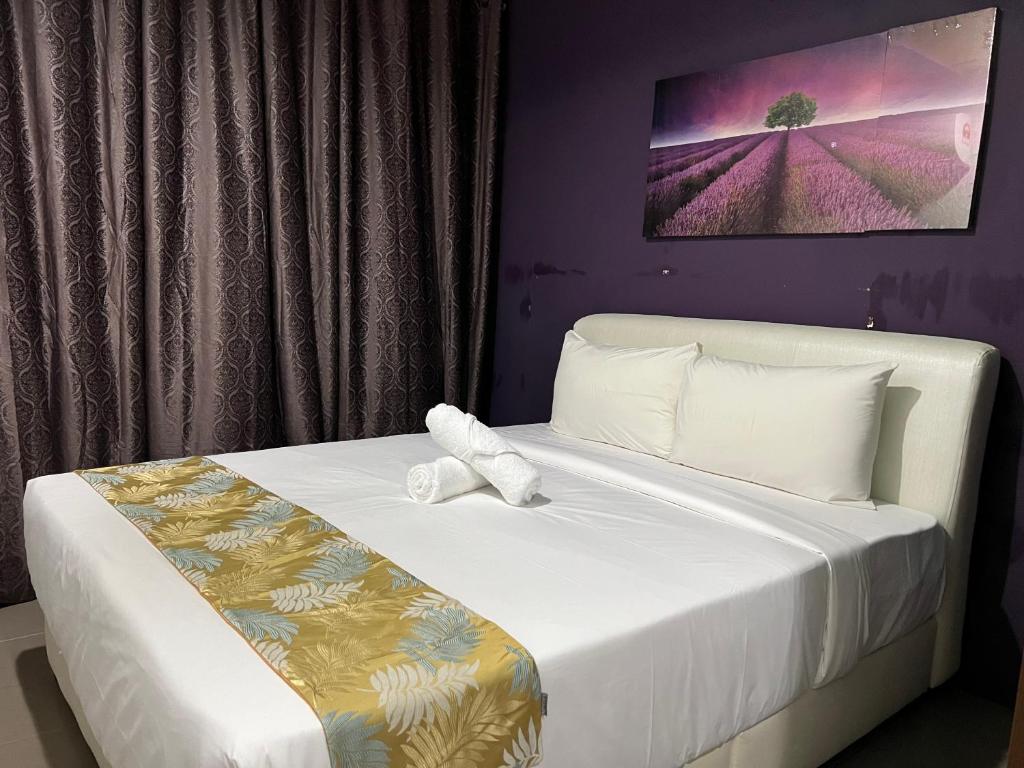 古晋Cassia Inn Kuching的卧室配有白色床和紫色墙壁