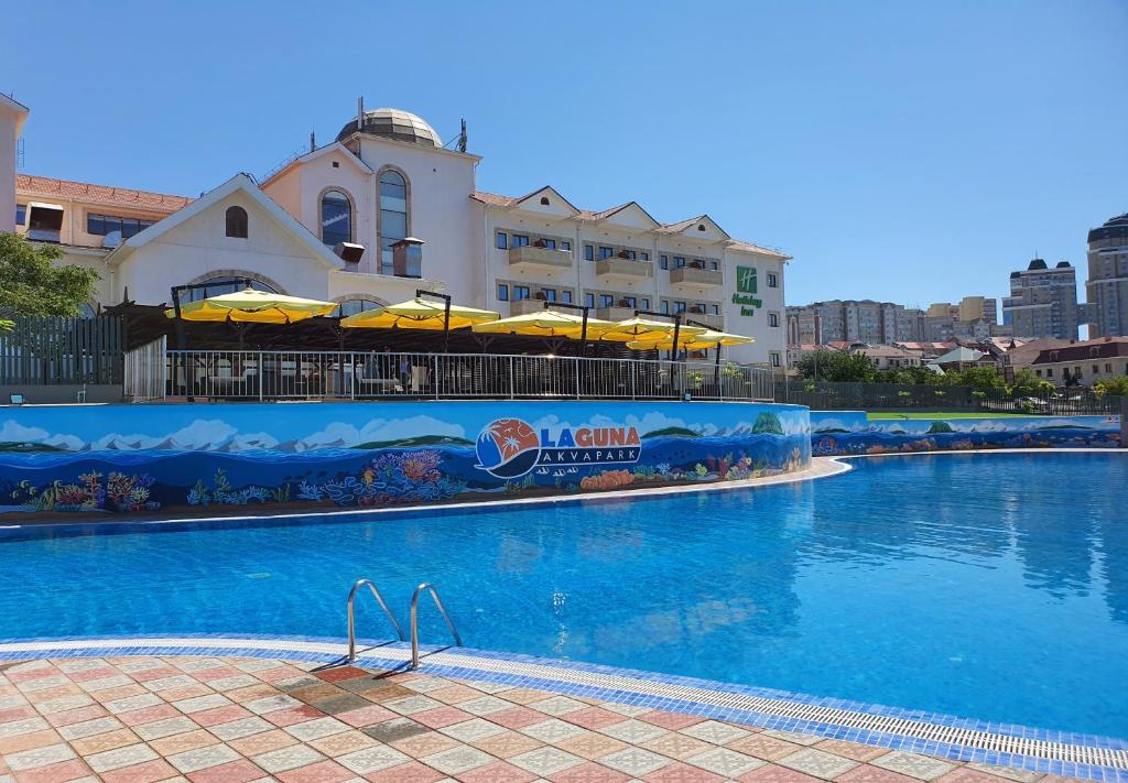 阿克套Holiday Inn - Aktau - Seaside, an IHG Hotel的一座大型游泳池,其建筑背景为: