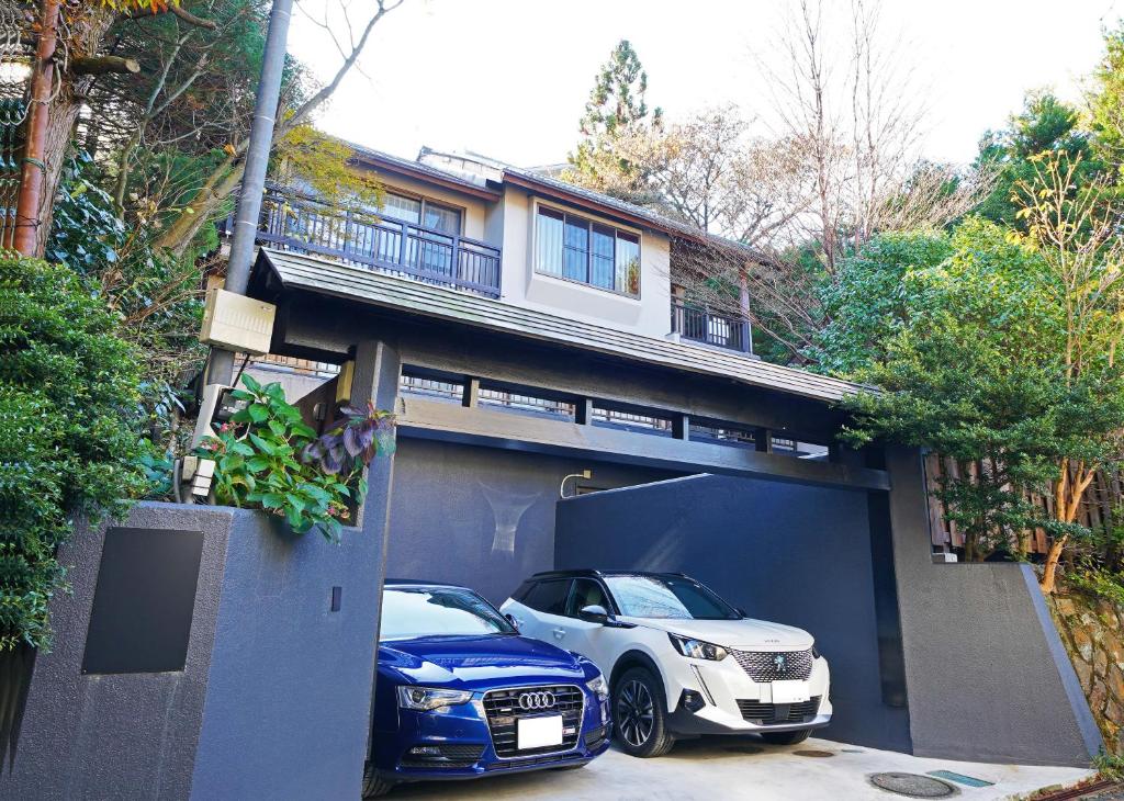 箱根Villa Liberte Hakone Gora的两辆车停放在车库的房子