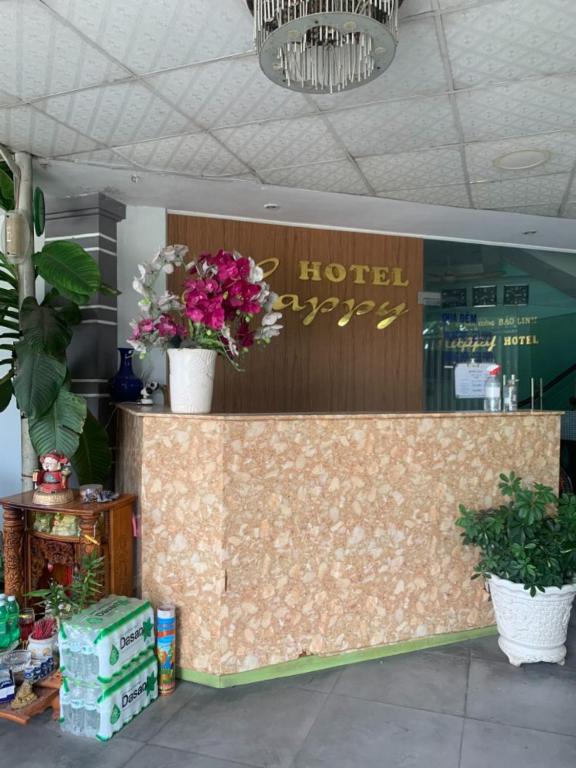 胡志明市Happy Hotel Binh Tan的上面有鲜花的酒店柜台