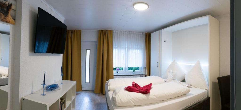 达姆施塔特Apartment-EG-09的卧室配有白色床,上面有红色的弓
