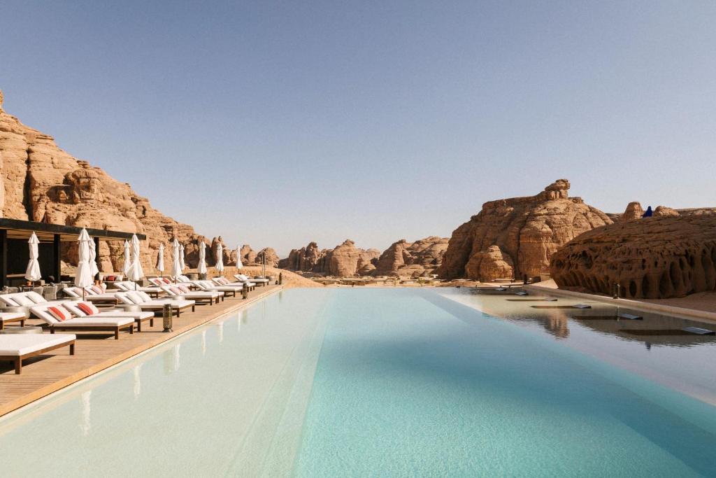 欧拉Our Habitas AlUla的沙漠中的游泳池,带椅子和岩石