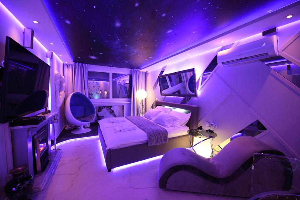 贝尔格莱德Aurora Lux Spa Smart apartments的紫色客房,配有一张床和一台电视机
