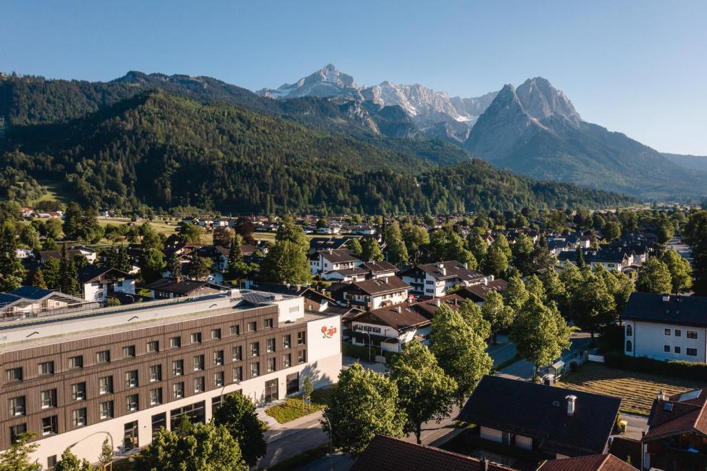 加尔米施-帕滕基兴aja Garmisch-Partenkirchen的享有小镇的空中景色,以群山为背景