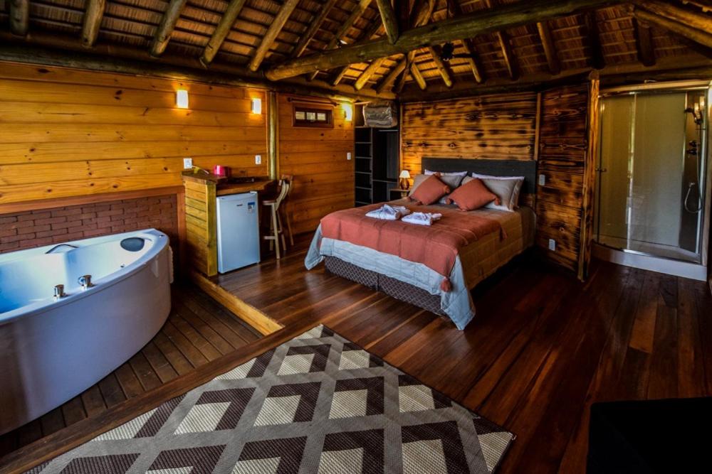 托雷斯Refugio monte itapeva的小屋内设有一间带床铺和浴缸的卧室