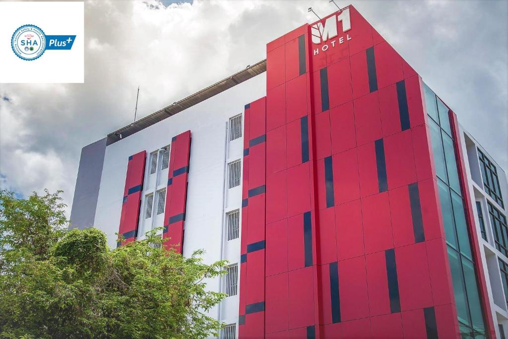 洛坤府M1 Hotel的一面有标志的红色建筑