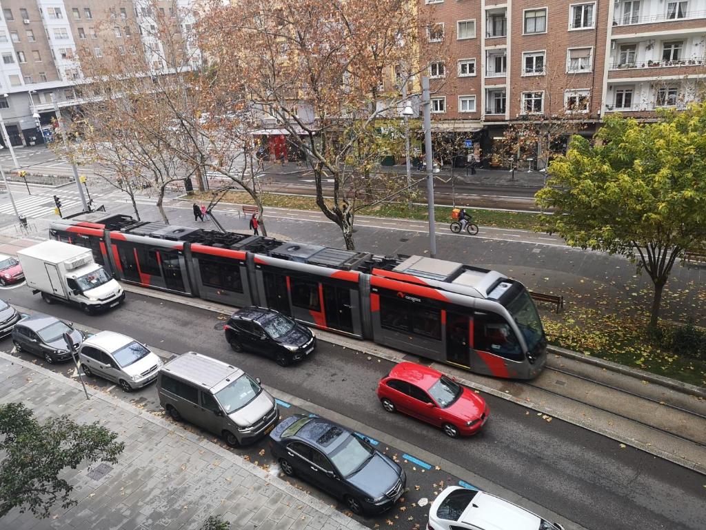 萨拉戈萨LC Gran Vía的一辆城市街道上的火车,有停放的汽车