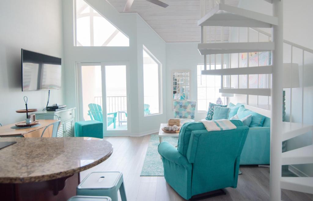 格尔夫海岸Grand Beach Resort Penthouse 1的客厅配有蓝色的沙发和桌子