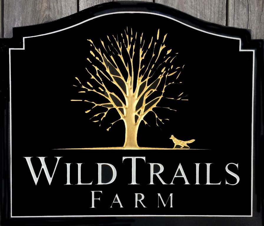 SpringfieldWild Trails Farm的种着树和鸟的野生动物农场的标志