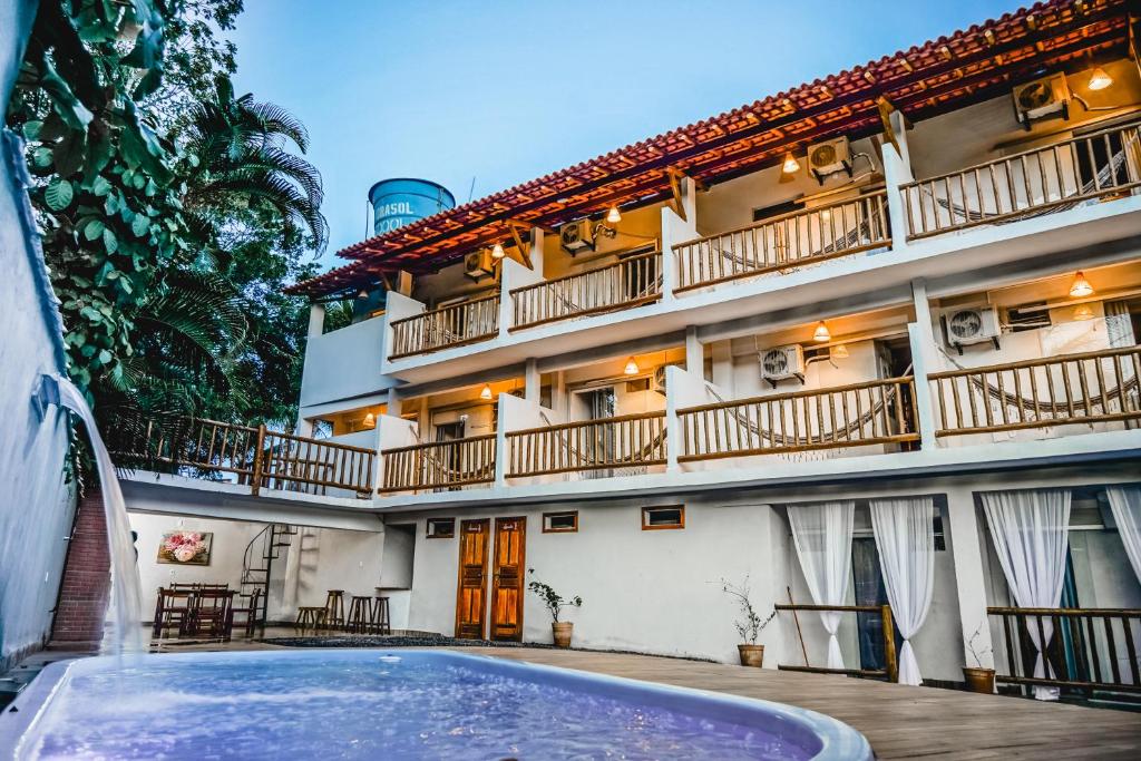 伊塔卡雷Vila Baiana Pousada的大楼前设有游泳池的酒店