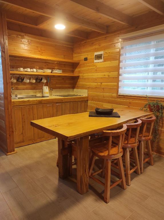 里坎雷Cabañas Los Arrayanes的木制厨房配有木桌和椅子
