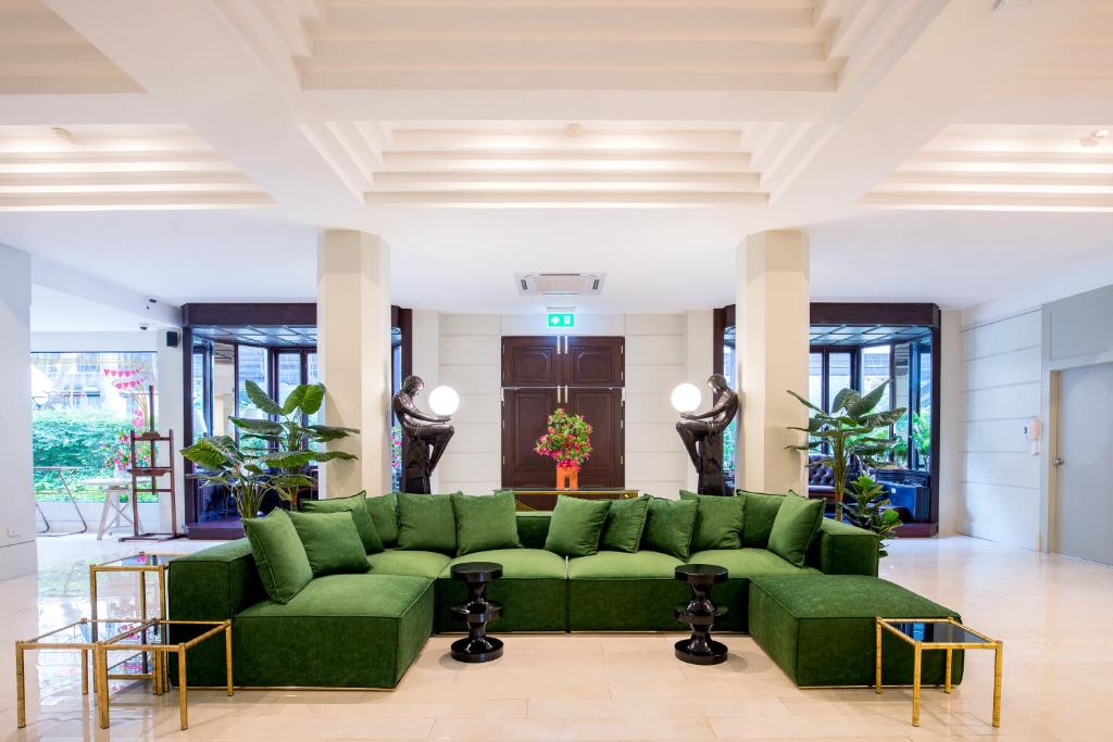 MakkasanHotel Thomas Bangkok的客厅配有绿色沙发和桌子