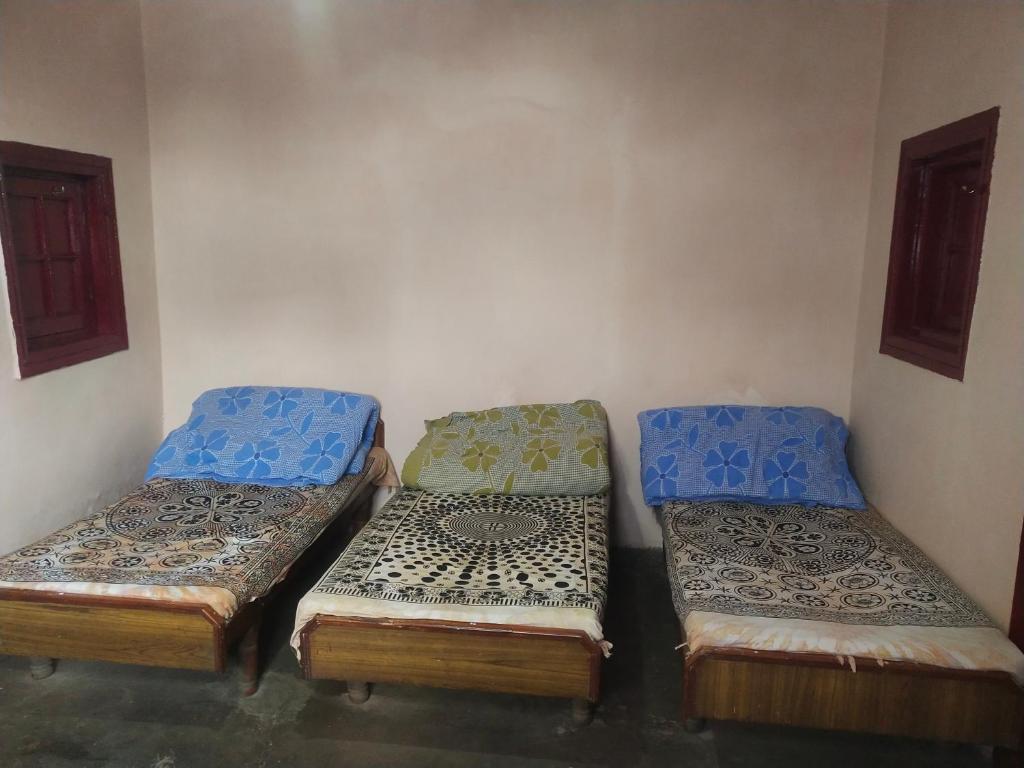 西姆拉Kumar Guest House的一间房间,有三张床