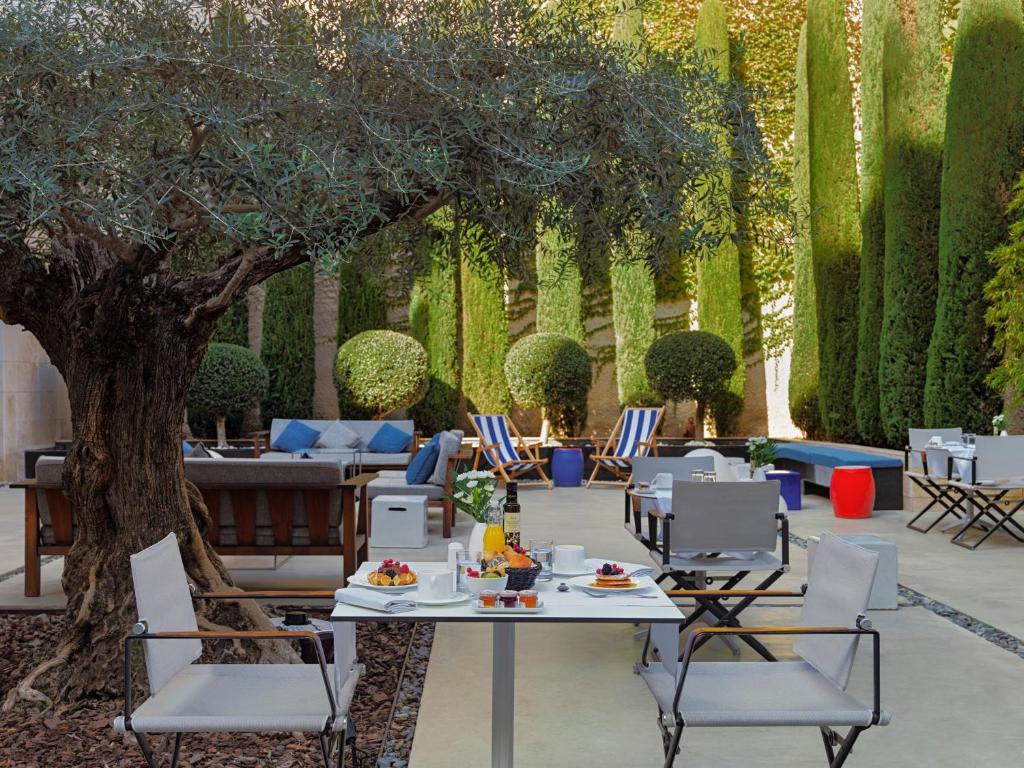 巴塞罗那H10美术馆4 *索普酒店的一个带桌椅和树的庭院