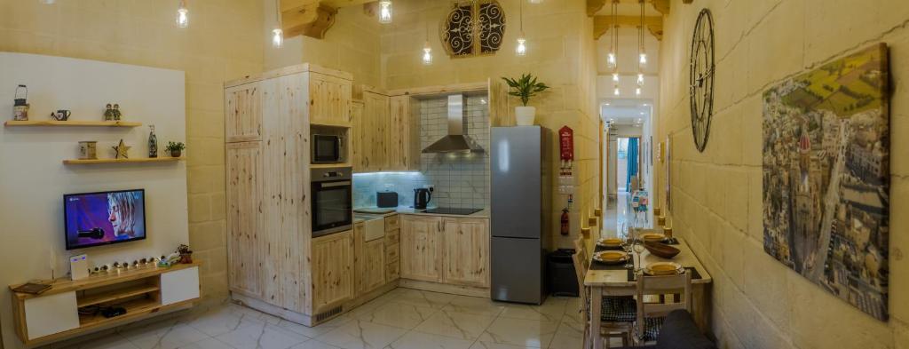 ŻabbarTa' Ġilard - Lovely Renovated Holiday Home的厨房配有木制橱柜和冰箱。