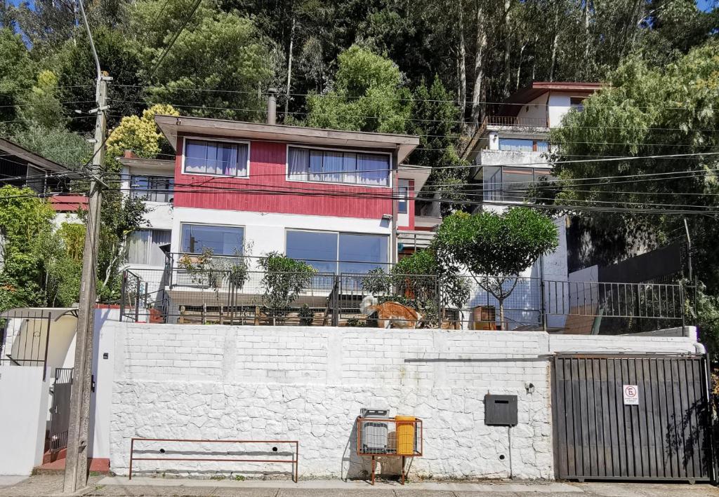 康塞普西翁Hostal Vivo Concepción的一座带栅栏的白色墙后面的建筑
