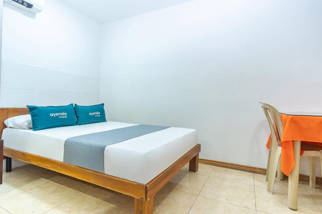 内瓦Ayenda Santander的床上有2个蓝色枕头