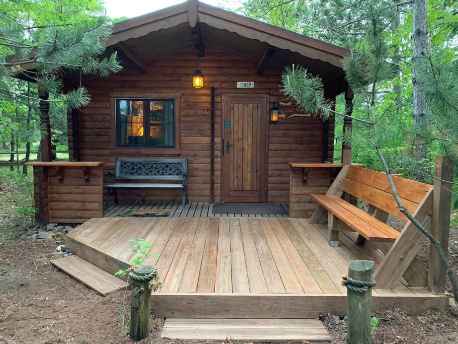 海沃德Honeybear Hideaway Cabin的木制小屋,设有木甲板上的长凳