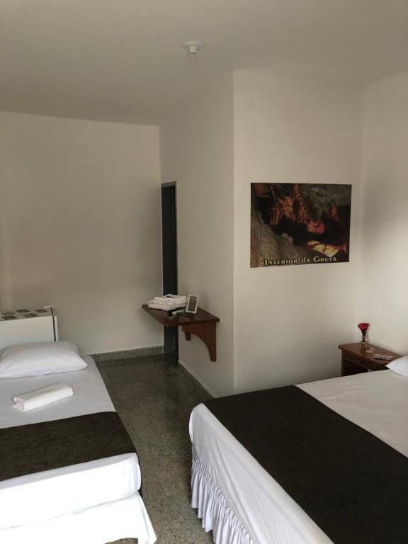乌巴雅拉Pousada Central-Ubajara Capital do Turismo的酒店客房配有两张床和一张书桌