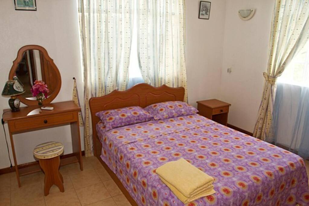 拉戈莱特Villa Palmistes Apartment的一间卧室配有一张床、一张桌子和一面镜子