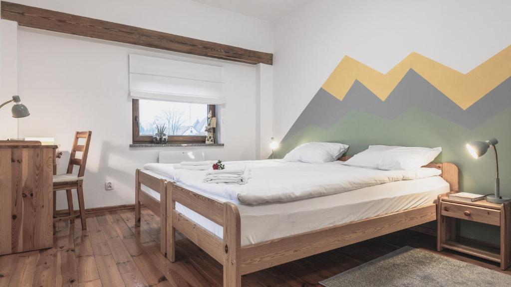 耶莱尼亚古拉Przystanek Czarne的卧室配有一张壁挂着山彩的床铺。