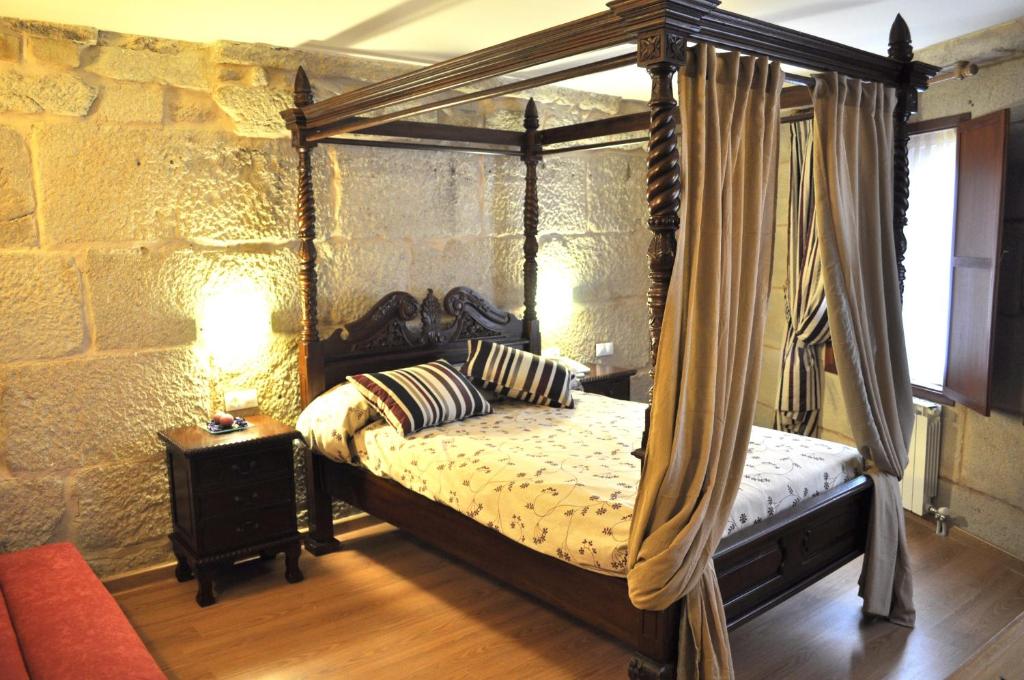 庞特维德拉宝维拉酒店的卧室配有一张石墙天蓬床