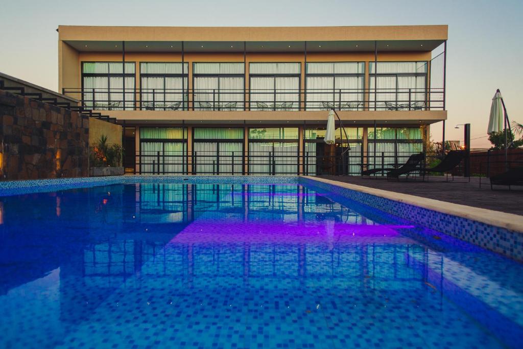 伊瓜苏港Paraiso Natural Apart Hotel Iguazu的一座建筑前的紫色游泳池