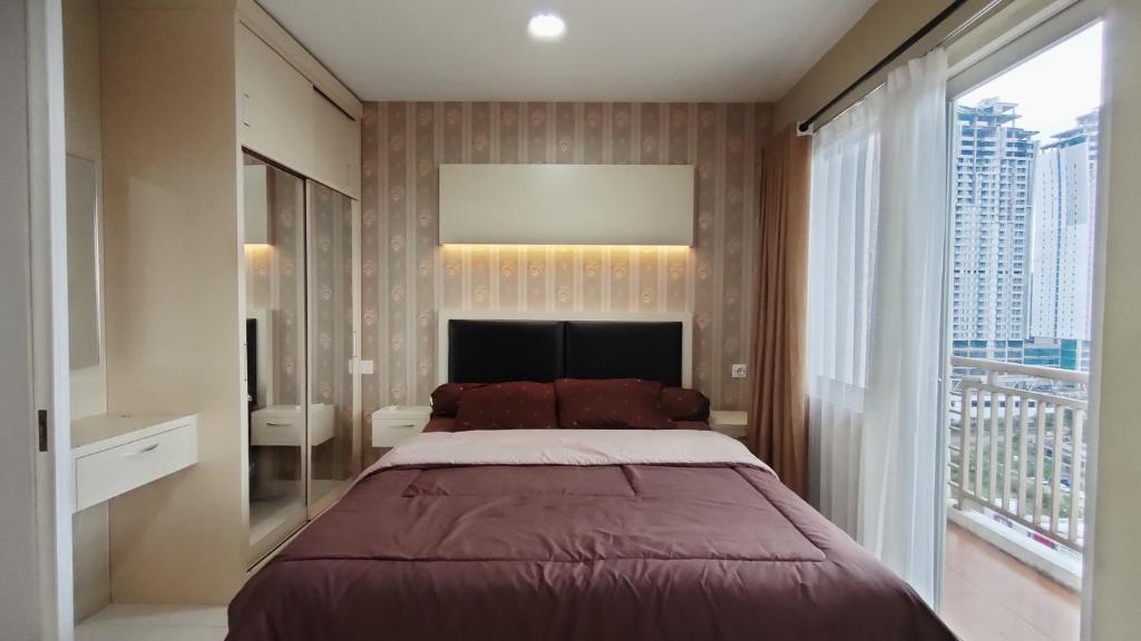 茂物Kozy Room Sentul Tower Apartemen的一间卧室设有一张大床和一个大窗户