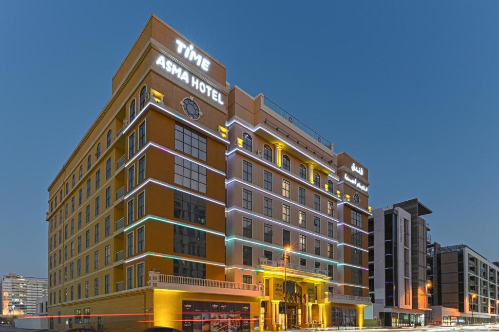 迪拜TIME Asma Hotel的一座大型建筑,上面有钟