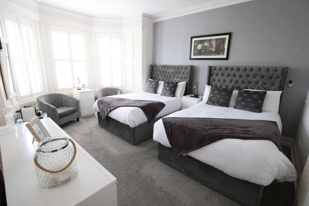 波特拉什曼德勒酒店的一间卧室配有两张床和椅子