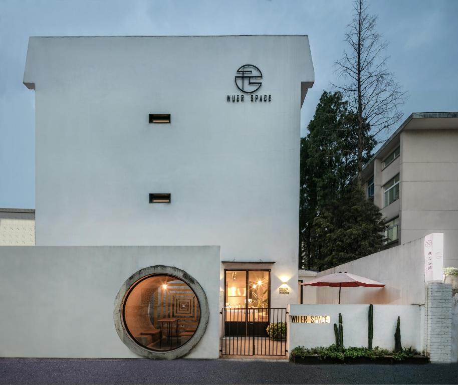 苏州苏州无二空间设计艺术酒店的白色的建筑,设有圆形窗户和雨伞