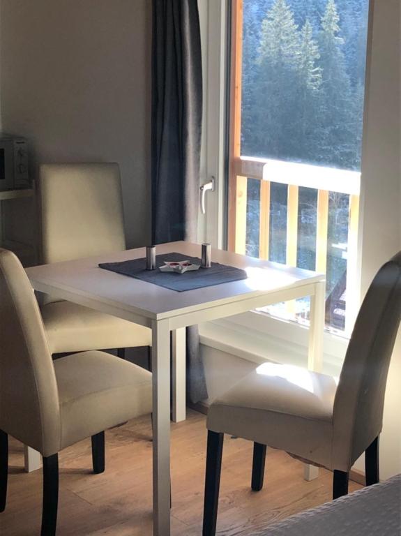 盖洛斯EMMA's Studio的一张带两把椅子的白色桌子和一扇窗户