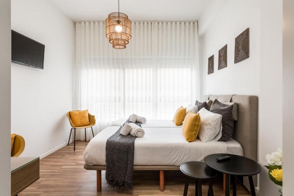 波尔图Porto Essence的一间卧室配有一张带黄色枕头的床