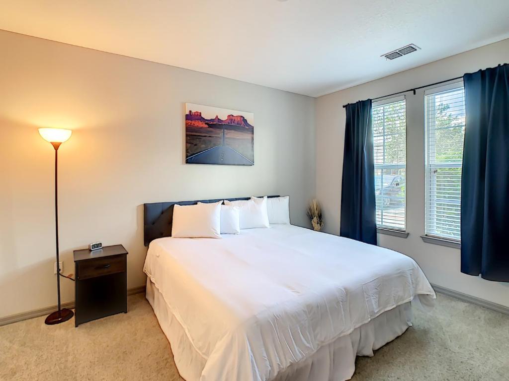 基西米King Bed, Great Amenities, And Disney Calling You的卧室配有一张带蓝色窗帘的大型白色床