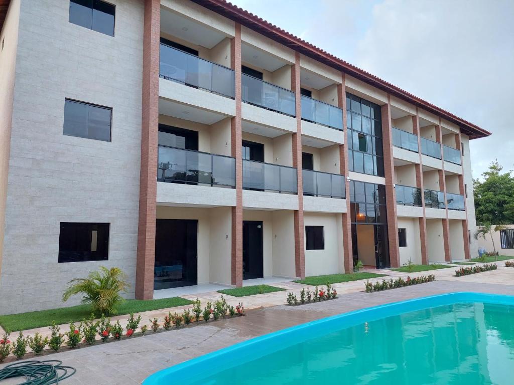 嘎林海斯港Flat Casa da Praia的公寓大楼前方设有游泳池