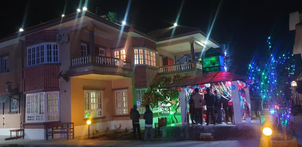 比拉特纳加尔London House Resort的一群人晚上站在建筑物外面