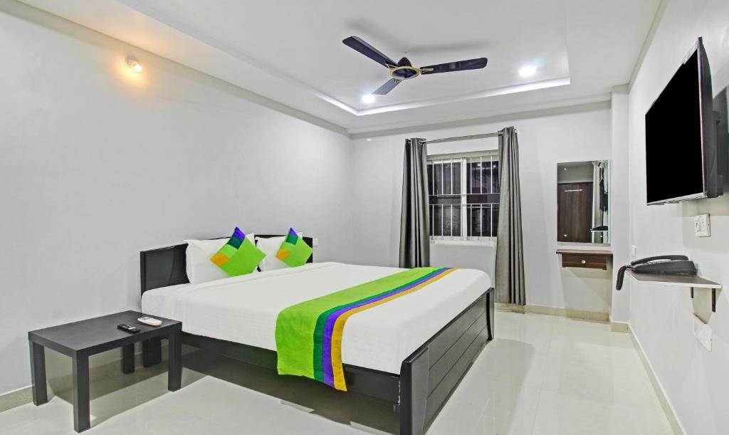 海得拉巴Itsy Hotels Sunrise Grand的一间白色卧室,配有床和电视