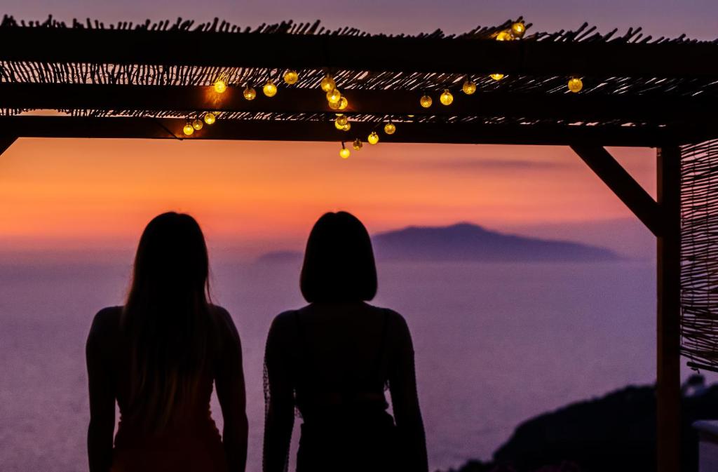 阿纳卡普里基拉索尔II号酒店的两位女士站在山顶,欣赏日落